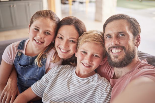 Family, children and parents taking a selfie in their home on the sofa in a lounge with love, care